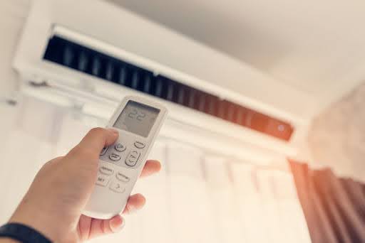 Person operating an air conditioner.