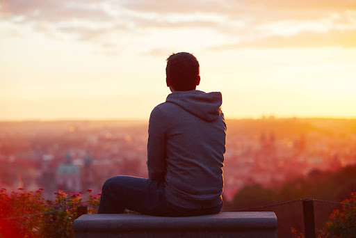 Man looking out at a sunrise.