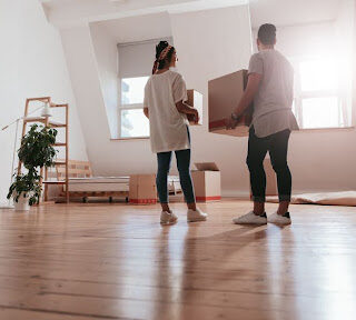 Couple standing with moving boxes.