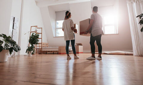 Couple standing with moving boxes.