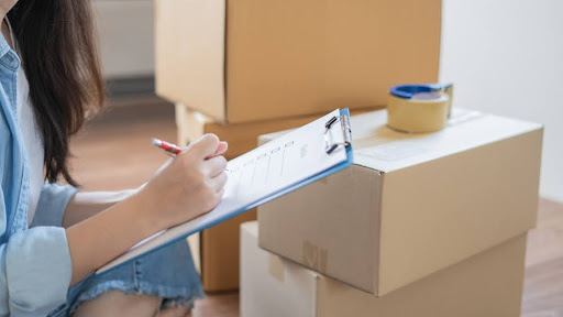 Person sitting next to boxes.