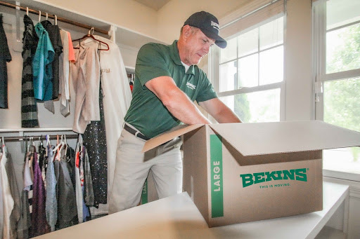 Bekins employee boxing up clothes.