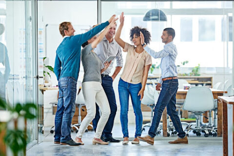 A group of employees share a collective high-five.